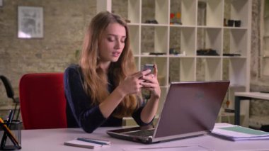 Güzel sarışın beyaz iş kadını duygusal Smartphone'da içerik tepki office içinde laptop önünde portresi