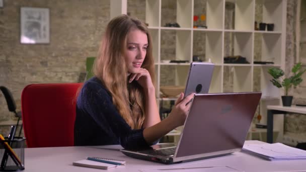 Retrato de atractiva rubia mujer de negocios caucásica delante de la computadora portátil en la oficina haciendo selfie-fotos usando tableta . — Vídeo de stock