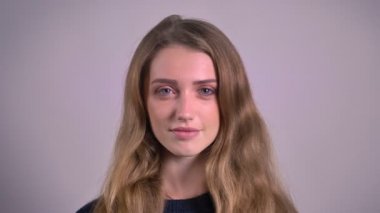 Sakin bir şekilde içine kamera gri arka plan üzerinde izlerken güzel sarışın beyaz genç kadın portresi