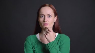 Kızıl saçlı çekici beyaz kadın düşünüyor ve gülen ve gülümseyen bir şey hatırlar