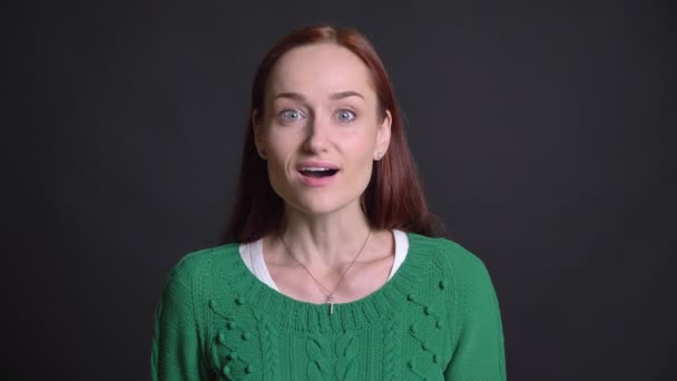 Closeup Kızıl saçlı olmanın çekici beyaz kadın kameraya bakarak ve gülümseyen birine dinleme sürpriz — Stok video