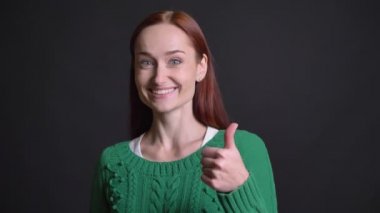 Çekici beyaz kadın Kızıl saçlı ve gri gözler gülümseyen ve başparmak gösterilmesini closeup