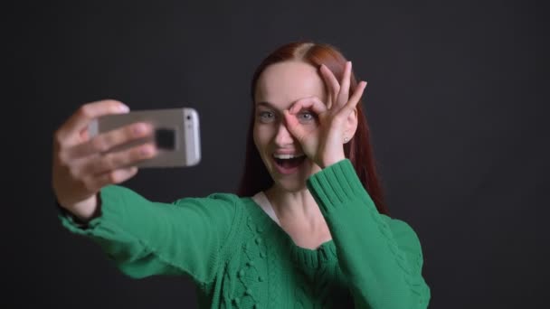 Nahaufnahme Porträt einer attraktiven kaukasischen Frau, die lächelnd Selfies macht und einen Affen glücklich spielt — Stockvideo