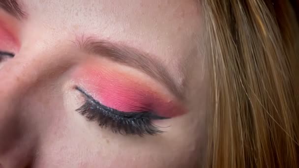 Nahaufnahme von atemberaubenden blauen Augen Make-up mit rosa Farbtönen und langen Wimpern auf dem Hintergrund der schönen Nachtlichter — Stockvideo