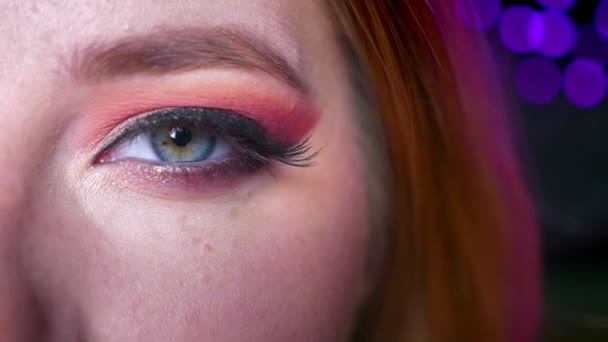 Zbliżenie, piękny niebieski oko makijażu różowe odcienie i błyszczy okiem patrząc prosto w obiektyw kamery — Wideo stockowe