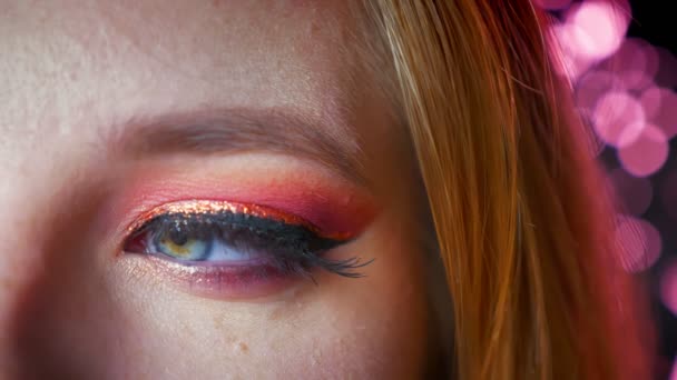 Close-up van verbazingwekkende vrouwelijke blauw oog make-up met tinten van roze en gouden eyeline. Eye op zoek naar de kant en vervolgens rechtstreeks naar de camera draaien — Stockvideo