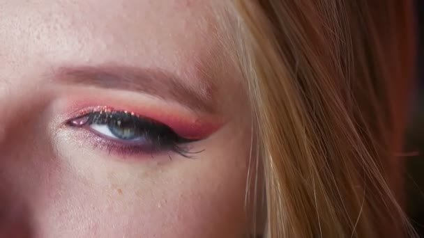 Nahaufnahme attraktiven weiblichen blauen Augen Make-up mit rosa Schatten und goldener Augenlinie. rechtes Auge auf Kamera gerichtet — Stockvideo