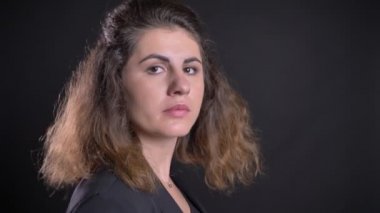 Yakın çekim kamera için dönüm ve sakin bir şekilde içine kamera siyah arka plan üzerine izlerken kilolu kafkas kadın portresi.