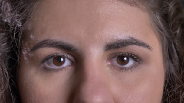 Nahaufnahme-Augenporträt einer übergewichtigen Kaukasierin, die direkt und lächelnd in die Kamera auf schwarzem Hintergrund schaut. — Stockvideo