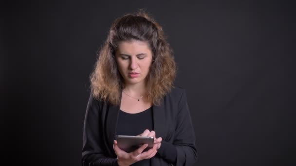 Close-up portret van overgewicht Kaukasische vrouw aandachtig werken met tablet toont groen scherm op zwarte achtergrond. — Stockvideo