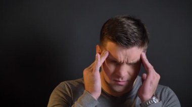 Orta yaşlı beyaz adam yapma masaj başağrısı siyah arka plan üzerine gelen yakın çekim portre.