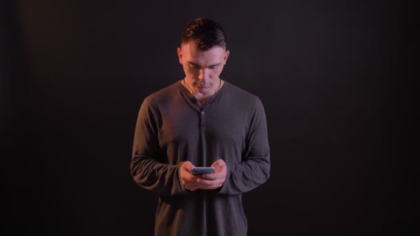 Closeup portrait of attractive caucasian fit man using and browsing on the phone and smiling — Stock Video