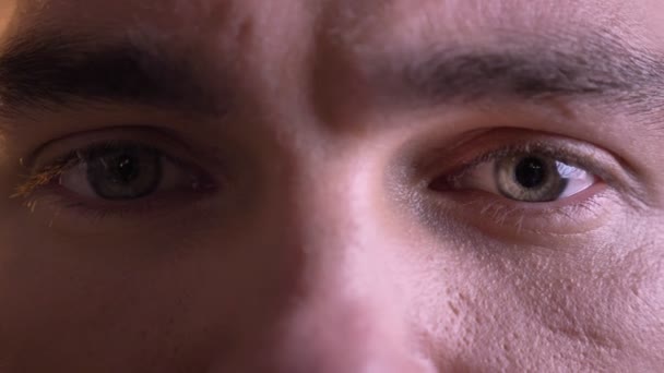 Closeup portrait of beautiful male eyes looking straight at camera and glooming facial expression — Stock Video