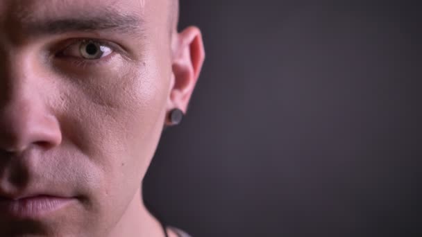 Closeup half-face portret van knappe Kaukasische man meteen kijken naar camera met zelfverzekerde en rustige gelaatsuitdrukking — Stockvideo