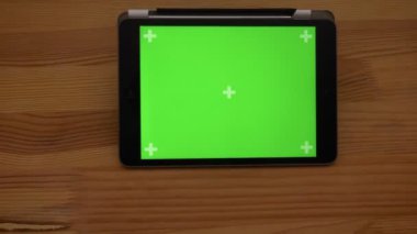 Ahşap Resepsiyon arka plan üzerinde yakın çekim yatay tablet ile yeşil ekran görüntüsünü daha yakın geliyor.