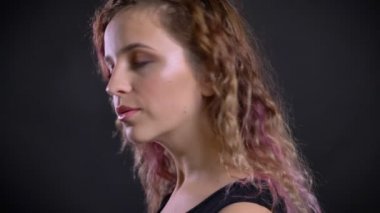 Kamera ve sakince siyah arka plan üzerine izlerken pembe saçlı Genç kız portresi yakından döner.