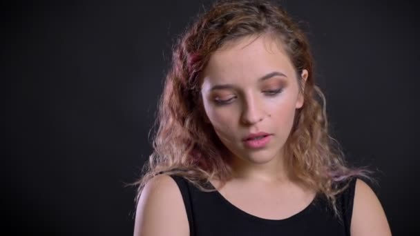 Porträtt av unga kaukasiska flicka med rosa hår i ödmjuk förvirring på svart bakgrund. — Stockvideo