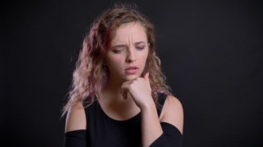 Düşünceli duran pembe saçlı Genç beyaz kız portresi bir bakış açısı siyah arka plan üzerine alır..