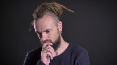 Dreadlocks ve düşünceli sakalını siyah arka plan üzerine dokunmadan piercing olan garip beyaz adam portresi yakın çekim.