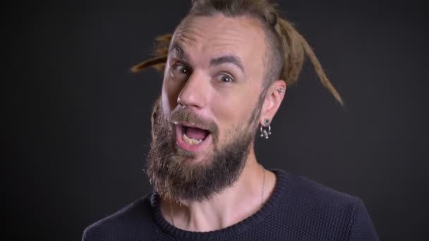 Close-up portrait of eccentric caucasian man showing positive amusement and happiness on black background. — Stock Video