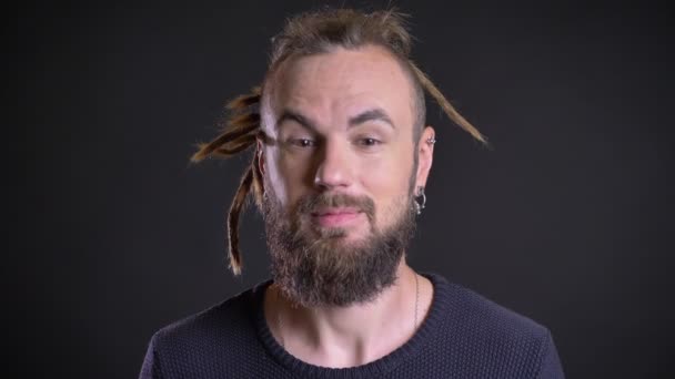 Close-up πορτρέτο της freaky Καυκάσιος άνθρωπος με dreadlocks δείχνει θετικό διασκέδαση και την ευτυχία σε μαύρο φόντο. — Αρχείο Βίντεο