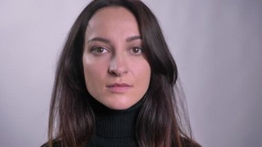 Genç Kafkas esmer kadın kamera gri arka plan üzerinde doğrudan izlerken portresi.