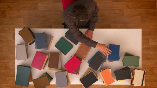 Stop motion shot góry człowieka przejściem rękę nad Znikające książki tabeli pobierania ich na smartphone. — Wideo stockowe