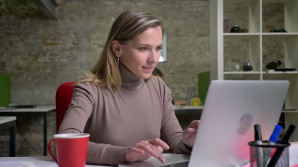 Nahaufnahme Porträt einer erfolgreichen Büroangestellten, die auf dem Laptop tippt und sich über einen neuen Sieg freut. Siegerkonzept — Stockvideo