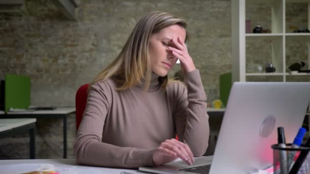 Primer plano retrato de cansada trabajadora de oficina agotada escribiendo en el portátil y teniendo un dolor de cabeza — Vídeos de Stock