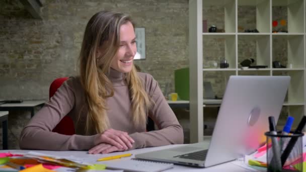 Primo piano ritratto di allegra femmina caucasica che fa una videochiamata seduta in ufficio al chiuso — Video Stock