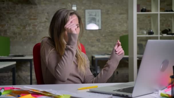 Primer plano retrato de atractiva mujer trabajadora de oficina caucásica felizmente bailando sentado delante de la computadora portátil en el interior — Vídeos de Stock