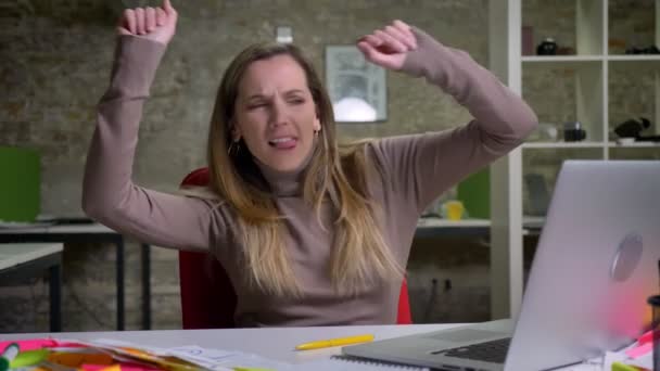 Closeup-portrett av artige, søte kvinnelige, hvite ansatte som danser og oppfører seg dumt på kontoret – stockvideo