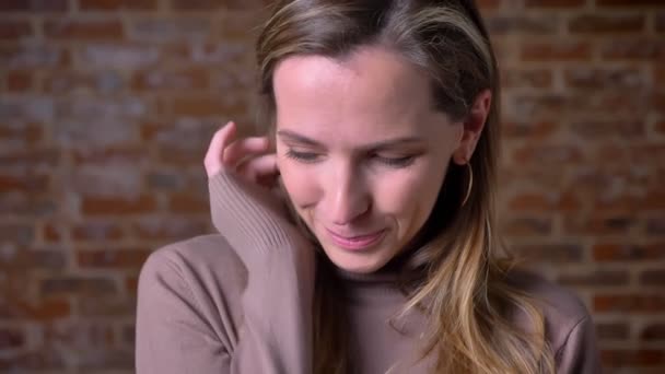 Detailní portrét krásné dospělé ženy při pohledu na fotoaparát roztomilé stanovení její vlasy a flirtování — Stock video