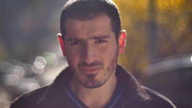 Beyaz delikanlı ağır kameraya sokak arka plan içine izlerken yakın çekim portre.