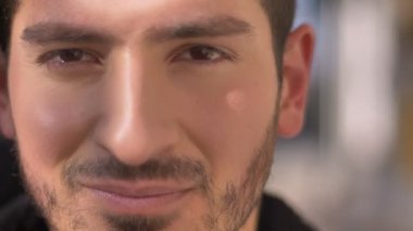 Yakın çekim portre alçakgönüllü üzerinde kameraya gülümseyen Genç beyaz adam arka plan bulanık.