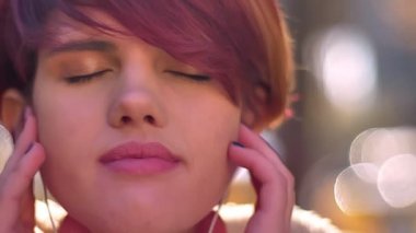 Müzik kulaklık ile memnuniyeti sonbahar park arka plan üzerinde beyaz pembe saçlı kız portresi yakın çekim