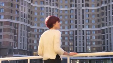 Arka-korkuluk ve urbanistic görünümü üzerinde izlerken yakın duran güzel pembe saçlı kız portresi