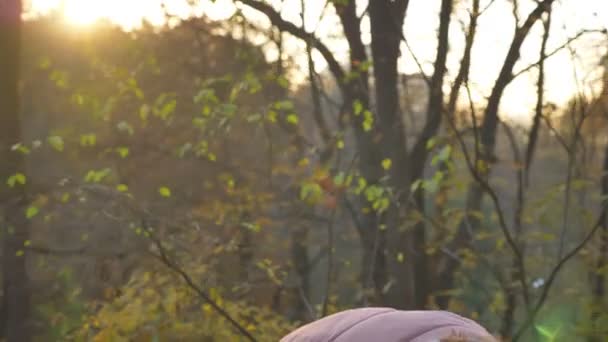 Yaprak toplama ve onları güneşli sonbahar parkta incelenmesi Genç beyaz kıvırcık saçlı kadın portresi. — Stok video