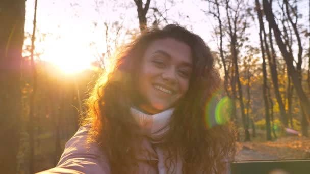 Авто-відео кавказької кучерявої жінки на сонці робить селфі-фотографії в автономному парку . — стокове відео