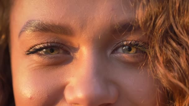 Close-up oog-portret van Kaukasische curly-haired vrouw glimlachend kijken in de camera op herfst park achtergrond. — Stockvideo