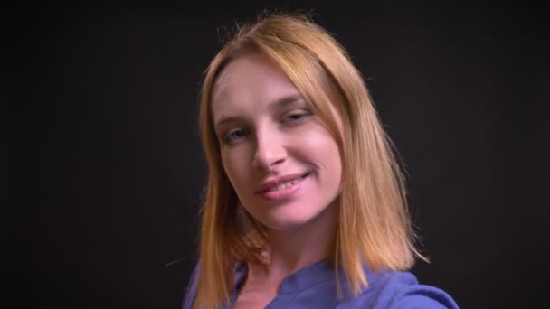 Self-video av kaukasiska blond kvinna i skjorta att göra selfie-bilder med hjälp av smartphone på svart bakgrund. — Stockvideo
