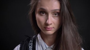 Yakın çekim portre sakin bir şekilde içine kamera siyah arka plan üzerine izlerken genç beyaz uzun saçlı kadın