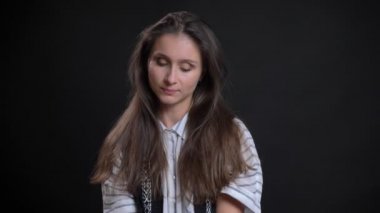 Alçakgönüllülükle kamera siyah arka plan üzerine içine izlerken genç beyaz uzun saçlı kadın portresi.