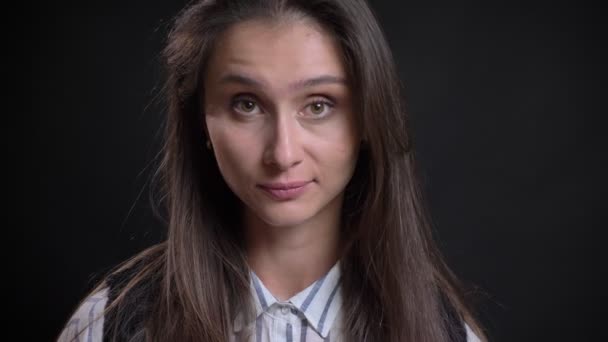 Portrét mladé kavkazské ženy dlouhé vlasy souhlasně přikyvuje do kamery na černém pozadí. — Stock video