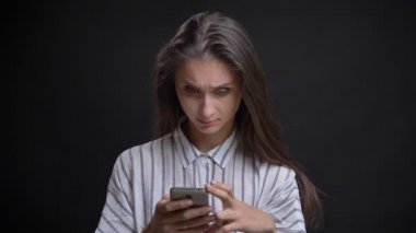 Smartphone izliyor ve siyah arka plan üzerine gülen güzel beyaz uzun saçlı kadın portresi.