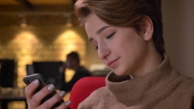 Kısa saçlı kadın hoş smartphone Office içine izlerken yakın çekim portre