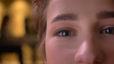 Yakın çekim yarı-portresi genç çekici kısa saçlı kadın sakin bir şekilde içine office kamerada izlerken.