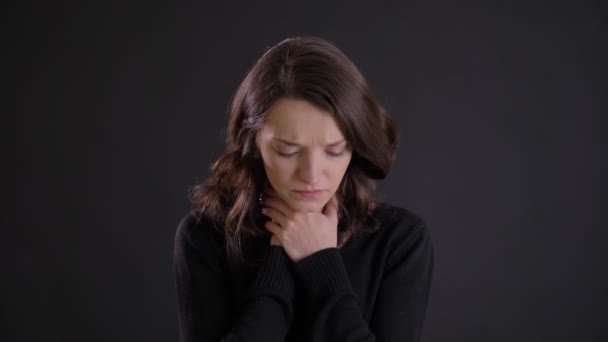 Porträt eines jungen attraktiven kaukasischen langhaarigen Mädchens mit Halsschmerzen auf schwarzem Hintergrund. — Stockvideo