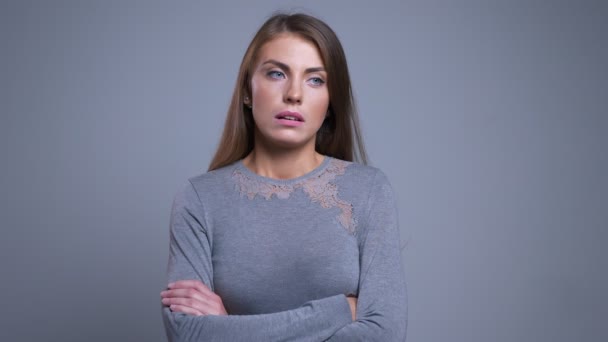 Retrato de cerca de una joven caucásica aburrida y triste con los brazos cruzados en el pecho y suspirando . — Vídeos de Stock