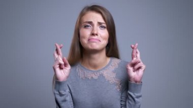 Portre portre umutlu Genç beyaz kadın kameraya bakıp onun parmak endişeyle çarpı işareti olan
